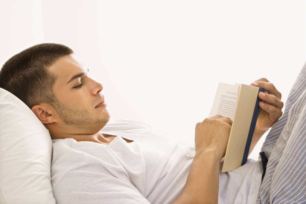 man reading book in bed 393d0